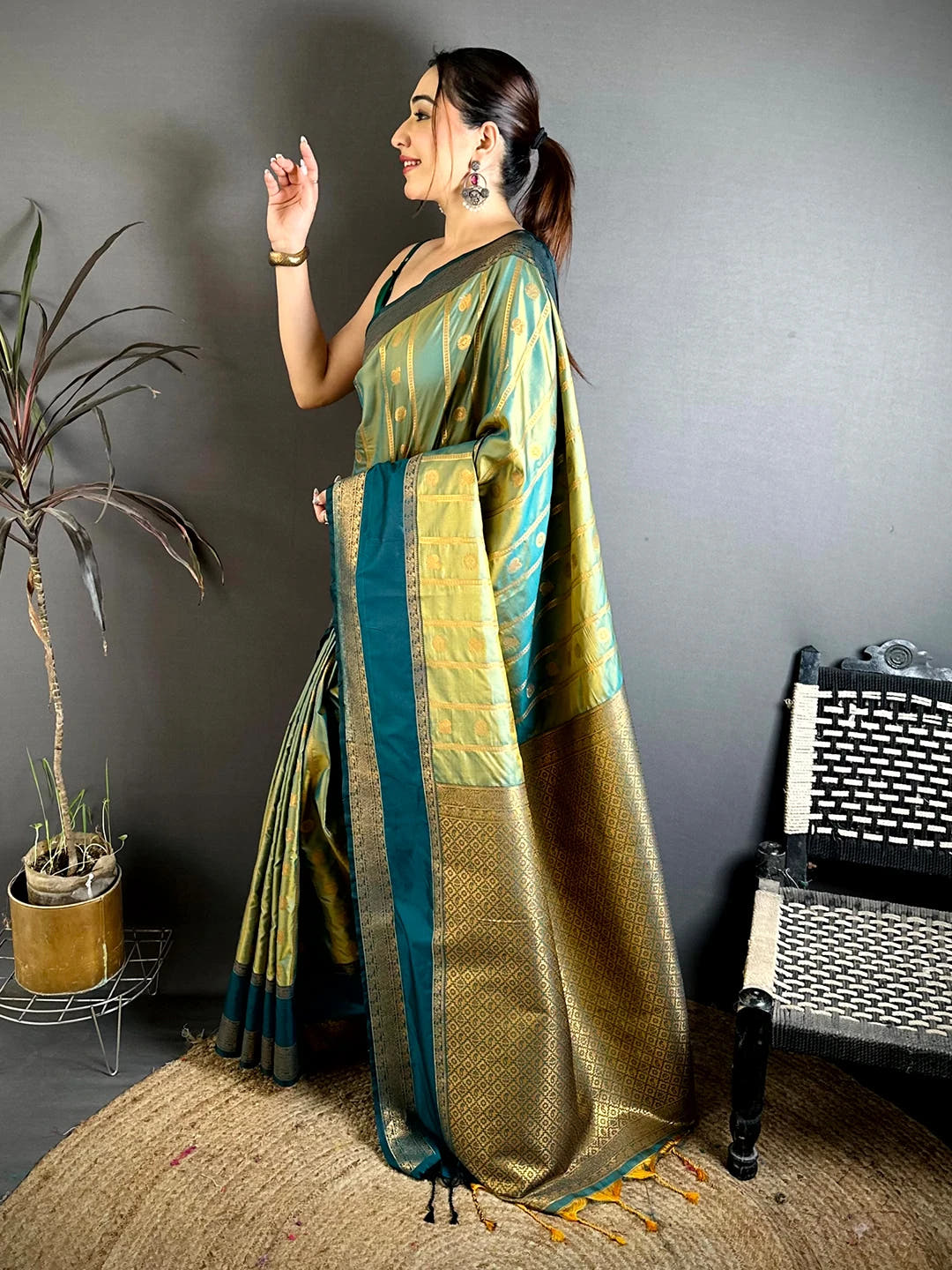 Pista green Banarasi silk zari butta saree, side view of the drape and teal border on the model