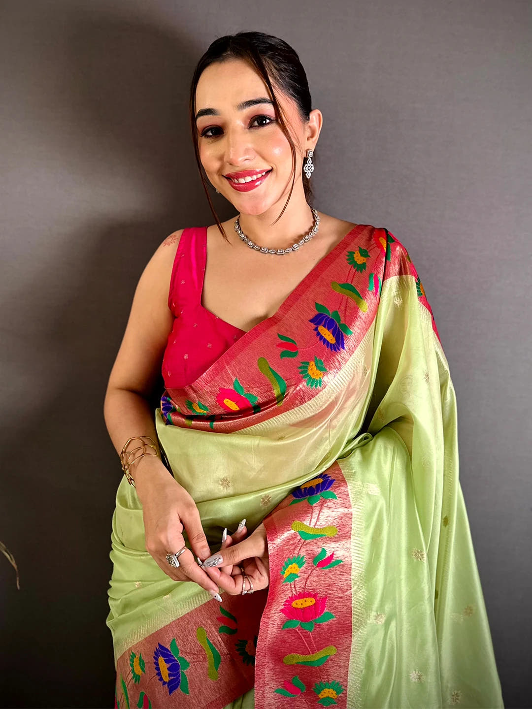 Pista green organza tissue Paithani minakari saree, model front drape showing pink zari border and lotus motifs