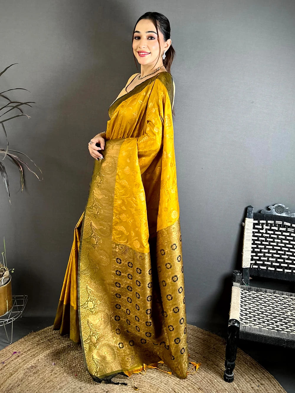 Mustard yellow soft silk peacock border saree, side view showing the drape and rows of circular buti on the pallu
