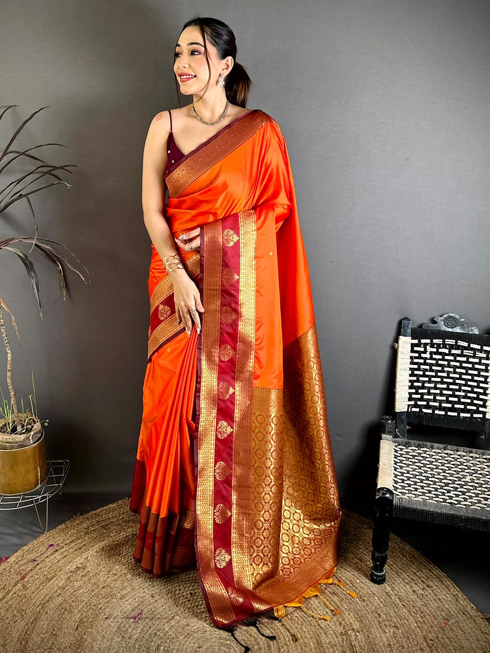 orange silk kanchi-style saree, full front drape on a model with gold buti motifs and the zari pallu falling to the floor
