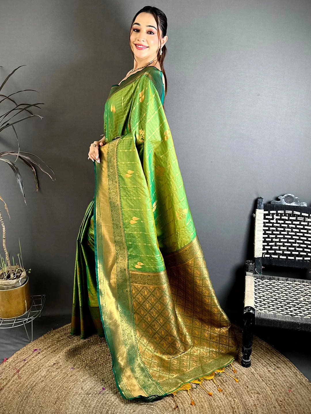 Green soft silk kanchi pattu-style saree, side view on a model showing the pleats and the gold woven pallu drape