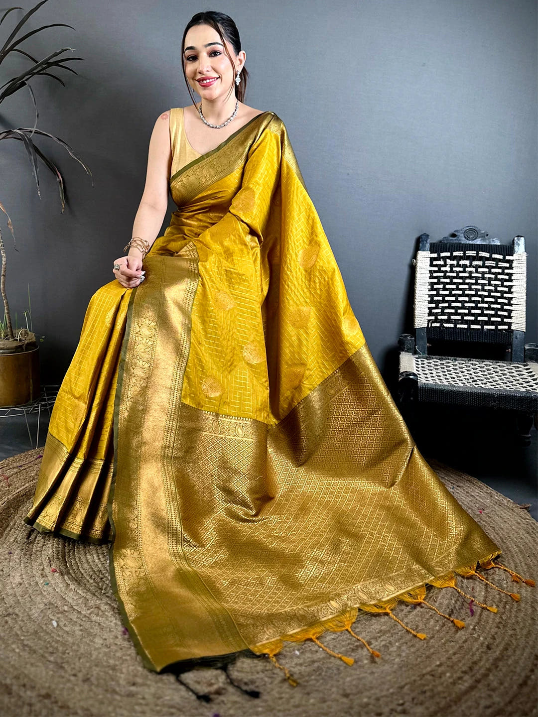 mustard silk checked zari saree, seated view with the zari pallu spread out and tassels at the end