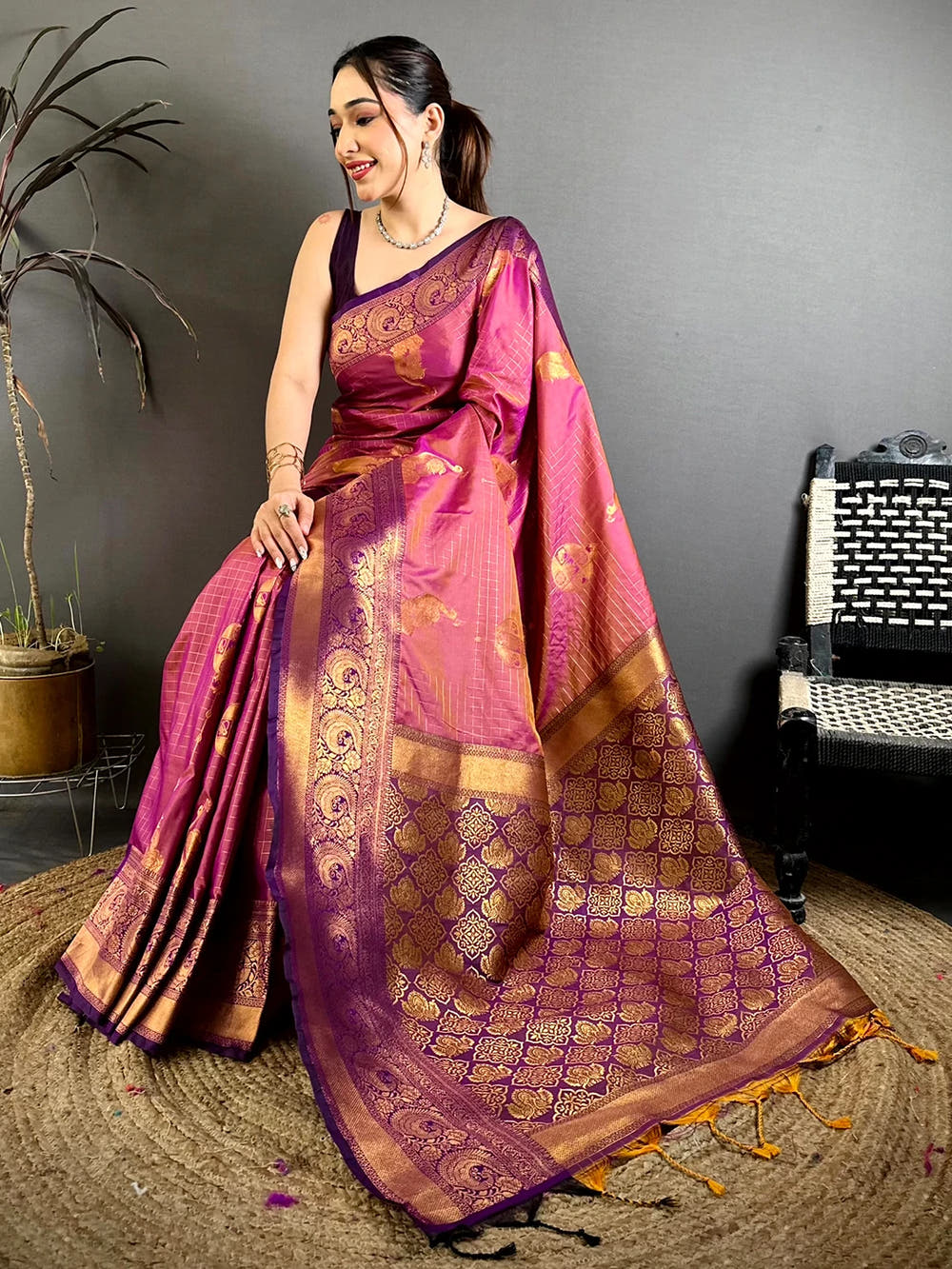Magenta Soft Silk copper zari weave saree, close-up of the pallu with golden tassels spread on a jute mat