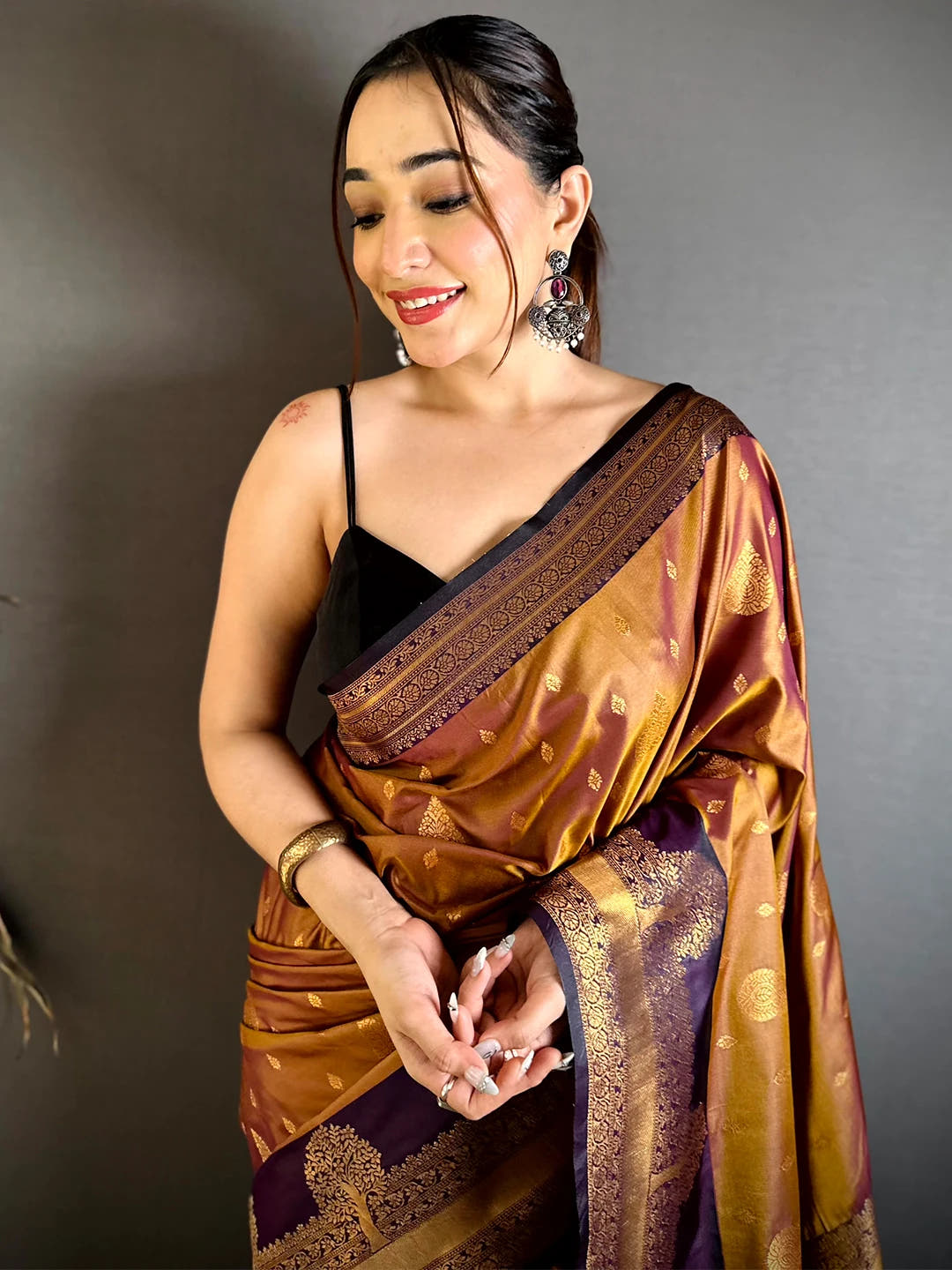 Copper soft silk tree Gadwal zari saree, model wearing the front drape with the purple border and gold zari butta