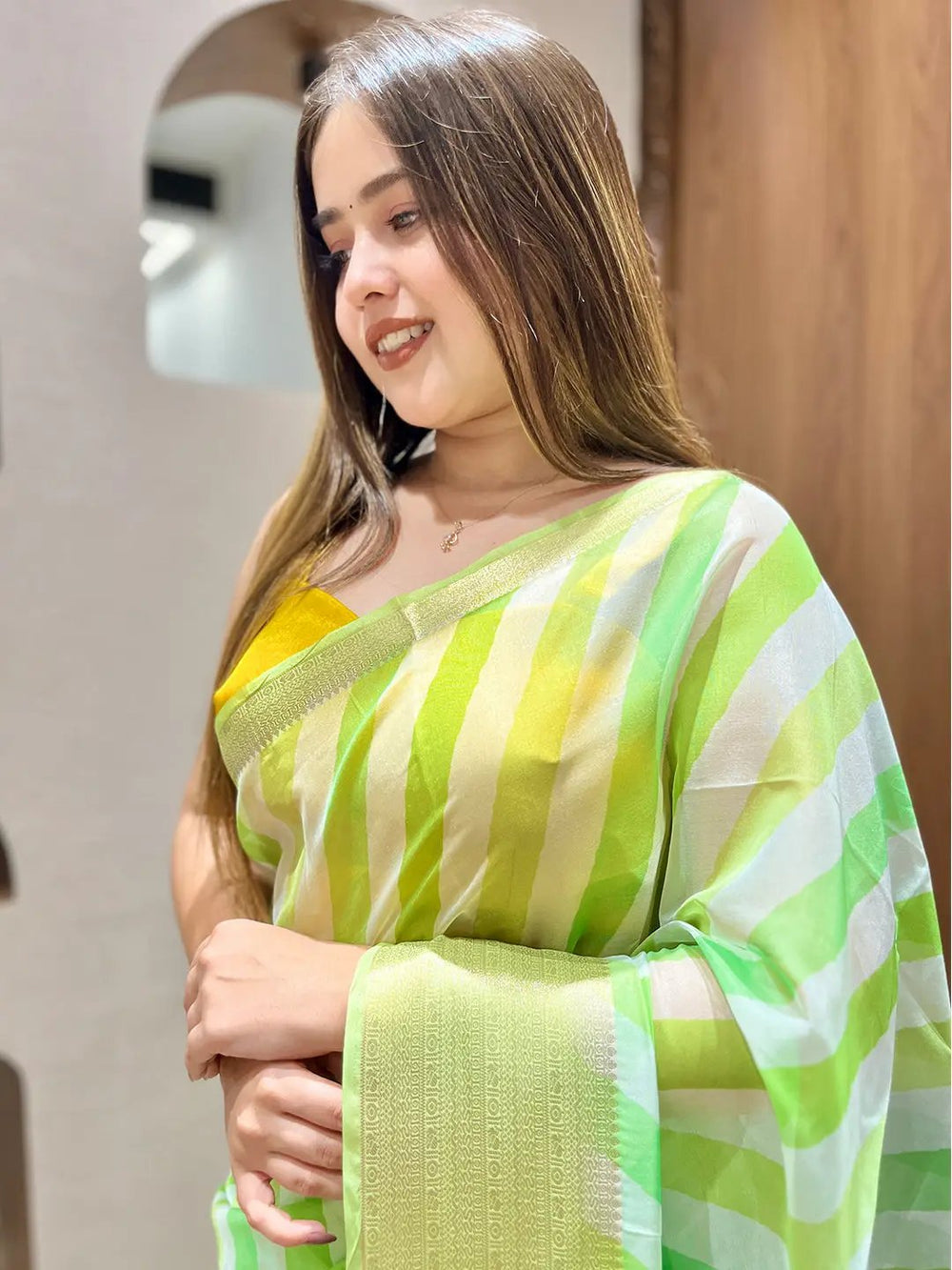 Close-up of green and yellow leheriya organza saree